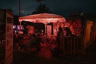 Eingang Fahrradkino, zwei Frauen an der Kasse neben Bauzäunen und Aufsteller.