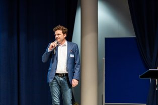 Prof. Dr. Christoph Schreiber (Photo: UW/H | Michael Schwettmann) A man speaks into a microphone.