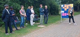 (Foto: UW/H | Kay Gropp) Es sind Menschen zu sehen, die an einer Tafel gemeinsam an einer Strategie arbeiten