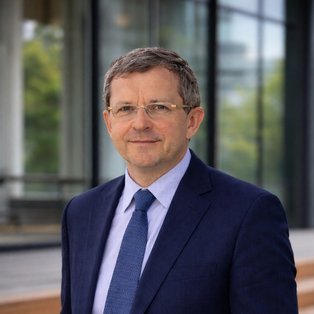 Ein Mann steht vor einem Gebäude.